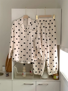 Detail of breathable cotton gauze pajamas featuring black heart prints and a chest pocket