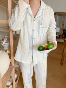 Detail of men's cotton pajamas with blue brushstroke patterns and button-up lapel collar