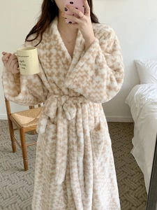 Detail of plush houndstooth bathrobe with waist belt in a cozy bedroom setting