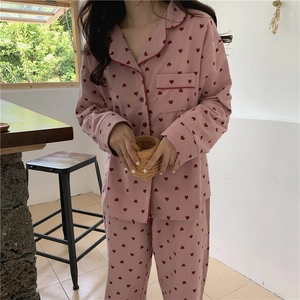 Detail of pink pajama set with heart print featuring red piping on the lapel and pocket
