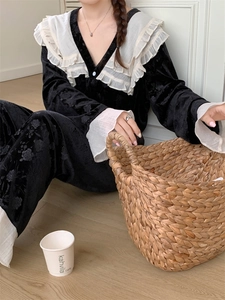 Détail du pyjama en velours noir avec texture rose 3D et volants blancs sur les bords
