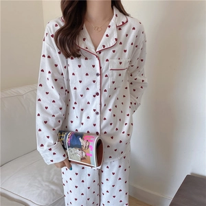 Detail of soft cotton pajamas with red heart prints and red piped notch collar
