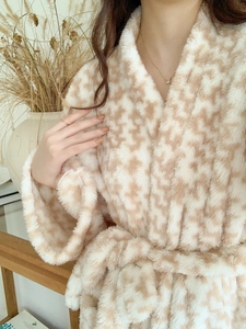 Detailed close-up of thick beige checkered plush bathrobe with soft flannel texture