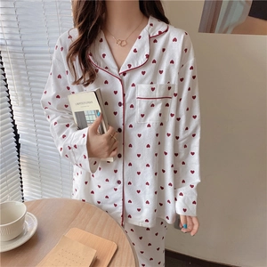 Detail of sweet heart print pajama set featuring red piping and a classic lapel collar