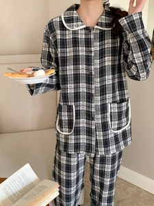 Close-up of black and white checkered pajama set with white Peter Pan collar and piping