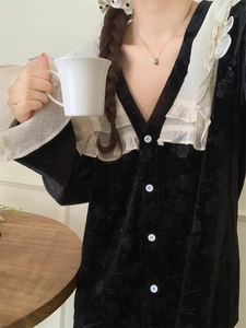 Détail du pyjama à col en V avec volants en dentelle et texture florale sur velours noir