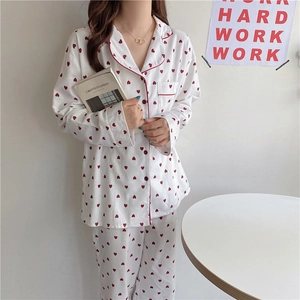 Sweet white pajama set with red heart print and piping detail shown in home setting