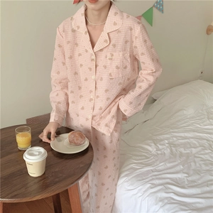 Détail d'un pyjama à carreaux rose clair avec motifs d'ours et col à revers en coton doux
