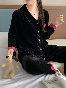 Détail d'un pyjama en velours noir avec bordure en dentelle sur les manches et le bas