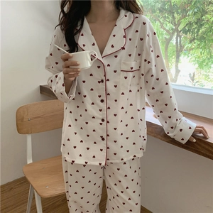 Detail of soft white pajamas set with red heart print and button-down collar lapel