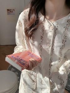 Détail de pyjama matelassé à fleurs avec col rond en dentelle et poches à nœud en ruban