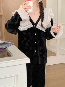 Vue détaillée du pyjama en velours noir pour femmes avec col à volants blancs et texture florale