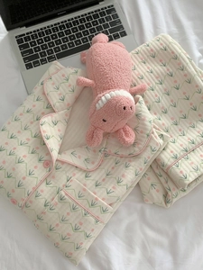 Detailed view of quilted cotton pajamas with pink floral print and matching plush toy