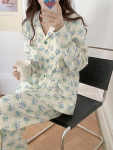 Detail of soft cotton pajama set with blue floral print and green checkered piping