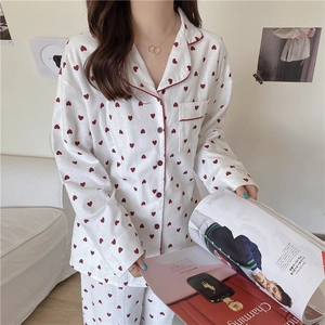 Detail of white pajamas with red heart prints and piping on the lapel and pocket