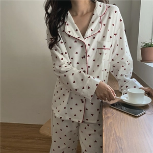 Detail of soft heart print pajamas with red piping on lapel and chest pocket