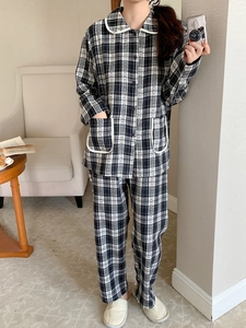 Detail of black and white checkered pajama set with white piping on collar and pockets