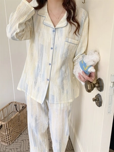 Detail of cotton pajamas with vertical stripes, blue piping, and single chest pocket