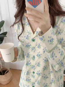 Close-up of floral cotton pajama top with green checkered trim and small blue flowers