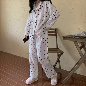 Detail of sweet heart-print pajamas showing soft cotton fabric and red piping trim
