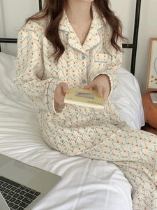 Detail of floral quilted pajamas set with blue piping and buttons in cozy indoor setting