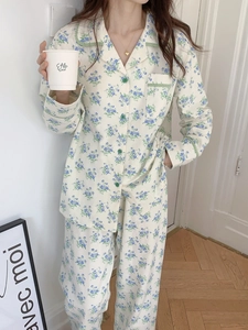 Detail of floral cotton pajamas featuring plaid trim, notched collar and green buttons
