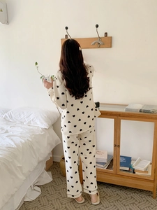 Detail of cream long sleeve pajama set featuring black heart print and ribbed texture