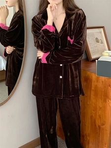 Détail d'un pyjama en velours marron foncé avec bordure en dentelle rose sur les manches