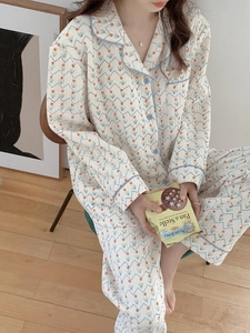 Detail of floral waffle knit pajama texture with blue trim and orange flower prints