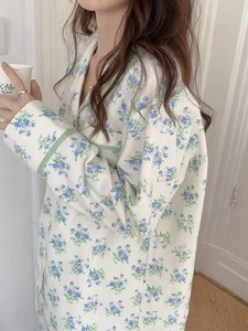 Detail of floral cotton pajama top featuring green checkered piping on the cuffs and collar
