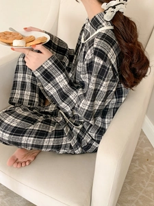 Detail of black and white plaid pajama set showing jacquard texture and white piping