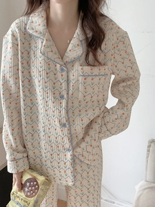 Detail of floral quilted pajama set featuring blue contrast piping and button closures