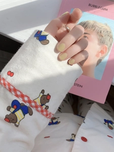 Détail de la manche d'un pyjama en coton avec motifs d'ours et poignets à carreaux rouges