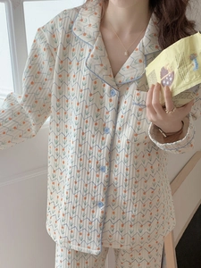 Detail view of floral quilted cotton pajama set with orange flowers and blue wave patterns