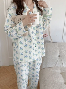 Close-up of floral cotton pajama set featuring blue flowers and green wavy trim details