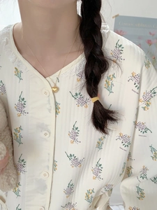 Detail of floral V-neck lace blouse paired with a golden heart pendant necklace