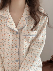 Detail of floral quilted pajamas featuring a notched lapel and blue piping finish