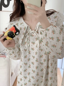 Detail of floral cotton nightgown featuring lace trim and ruffled collar design