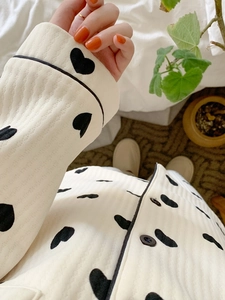 Detail of cream long-sleeve pajama top with black heart print and contrast piping trim