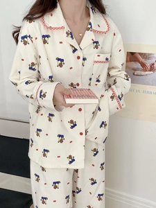 Détail d'un pyjama en coton doux avec imprimés d'ours et bordures à carreaux rouges