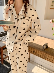 Detail of heart print pajamas set featuring contrast piping and notched collar design