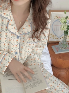 Detail of floral quilted pajamas with blue piping, tulip pattern, and buttoned collar