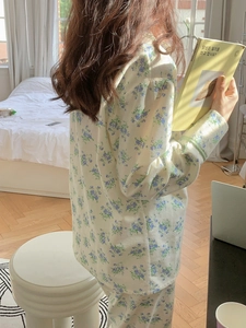 Detailed close-up of floral cotton pajama sleeve with green plaid cuff detail