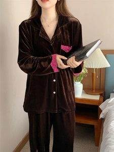 Détail de pyjama en velours marron foncé avec dentelle rose aux poches et poignets