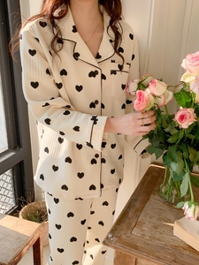 Detail of soft cream pajamas with black heart prints and elegant black piping accents