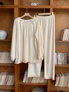 Dettaglio di un set lounge color crema in tessuto jacquard e bordi con frange
