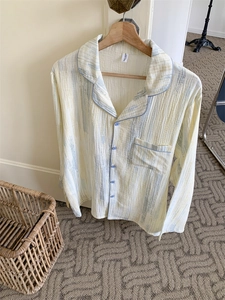 Close-up of a soft cotton pajama top with subtle abstract texture and blue button detail