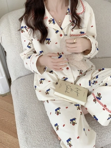 Détail d'un pyjama en coton doux avec ours imprimés et bordures à carreaux rouges