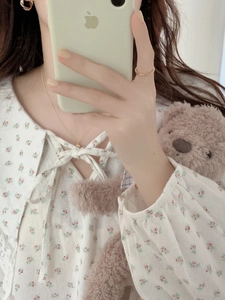 Close-up of floral cotton nightgown with bow tie neck and elasticated sleeve cuffs