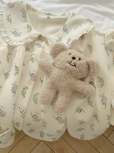 Detailed view of floral quilted pajama top with lace Peter Pan collar and plush bear